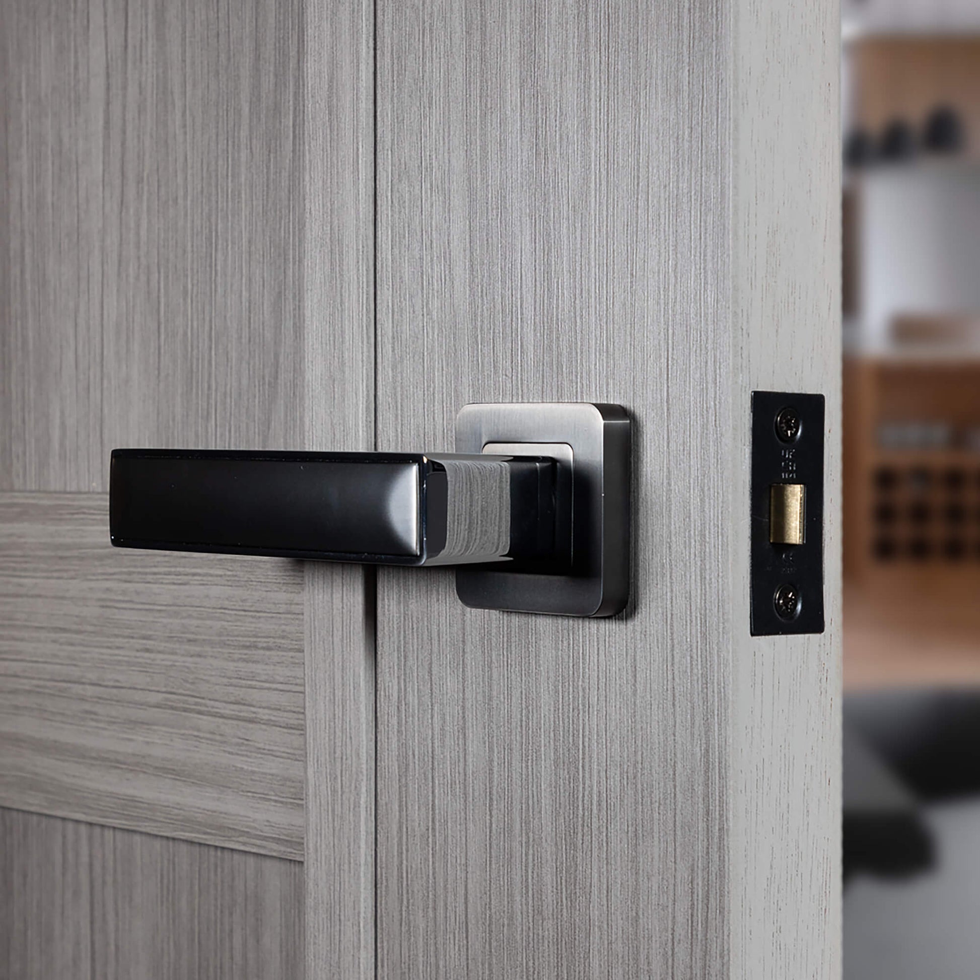 Close-up of a Alto Nickel Brushed & Polished Chrome Square Rose Handle on a laminate internal door with a blurred interior background.