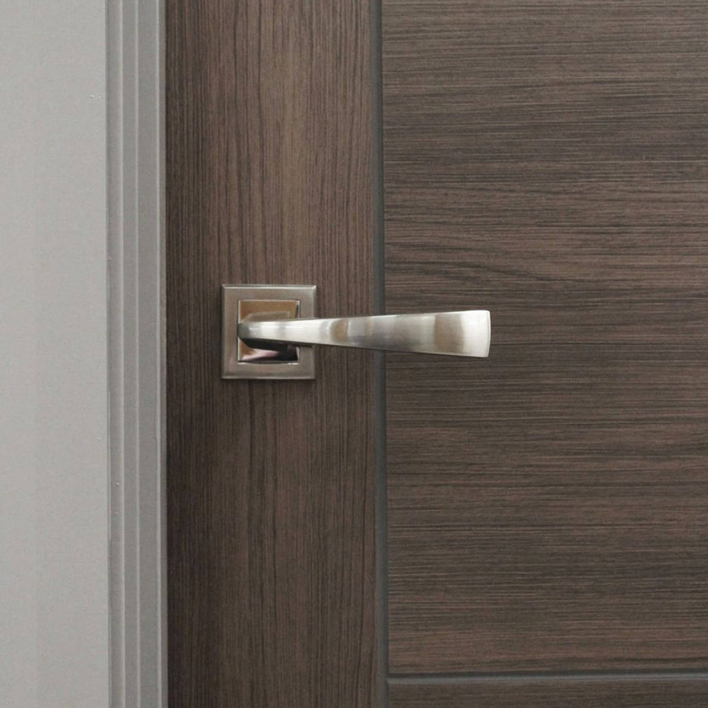Close-up of an Arcus Nickel Brushed & Polished Chrome Square Rose door handle on a walnut door