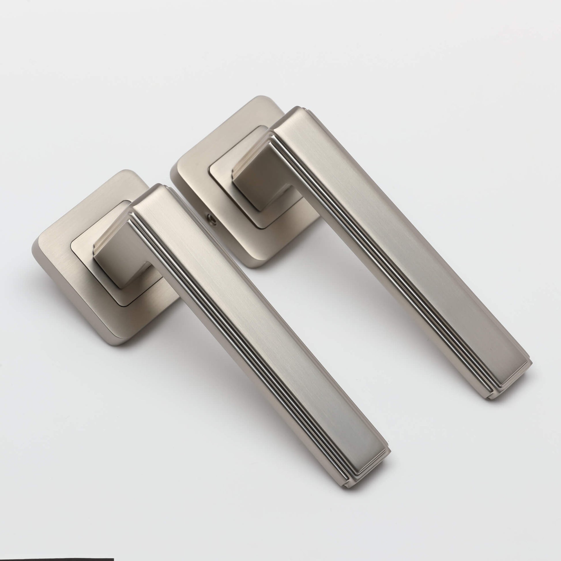 A view of a set of Ares Matt Satin Nickel Square Rose door handles on a white background.