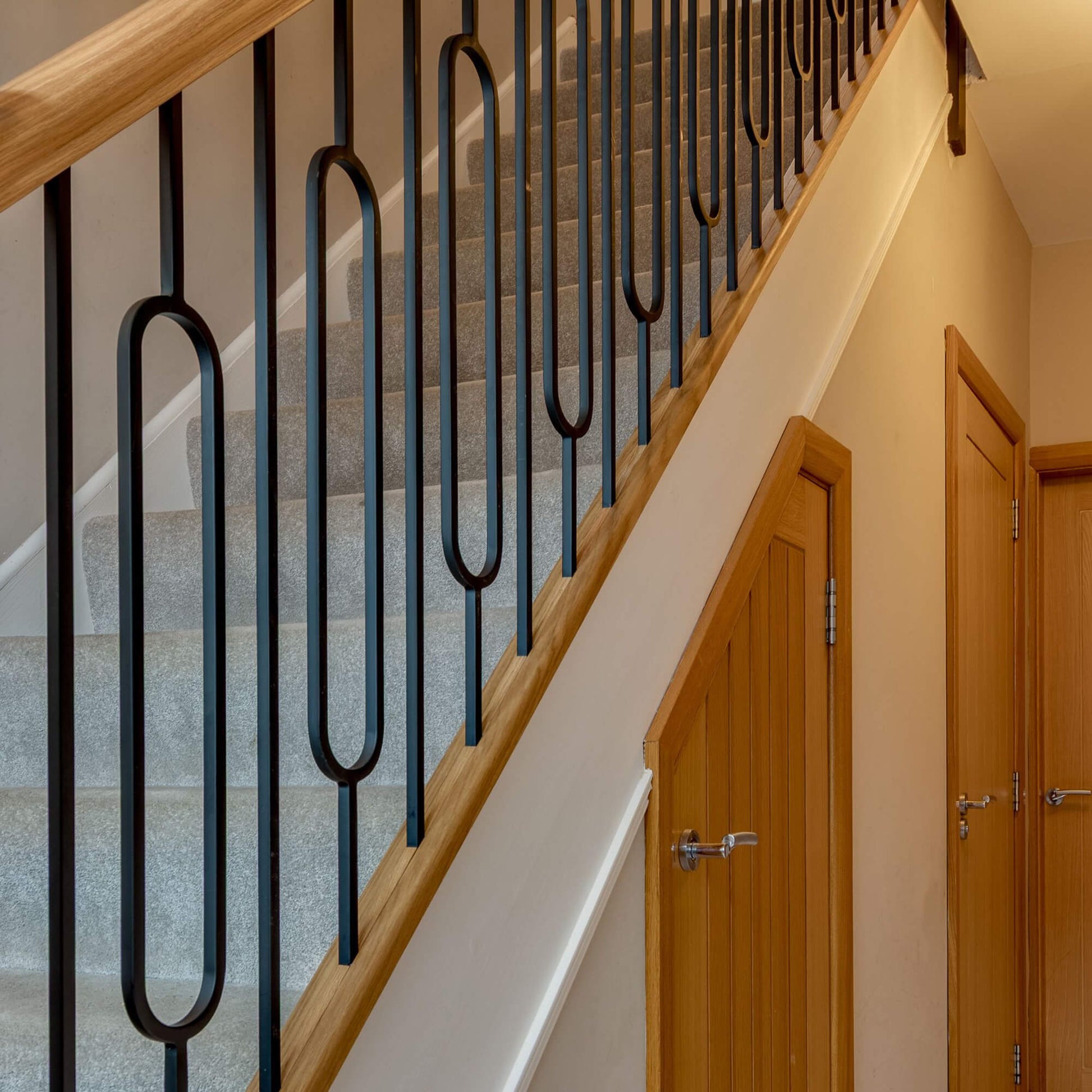 A staircase showcasing Black Oval Spindles in a downstairs home interior.