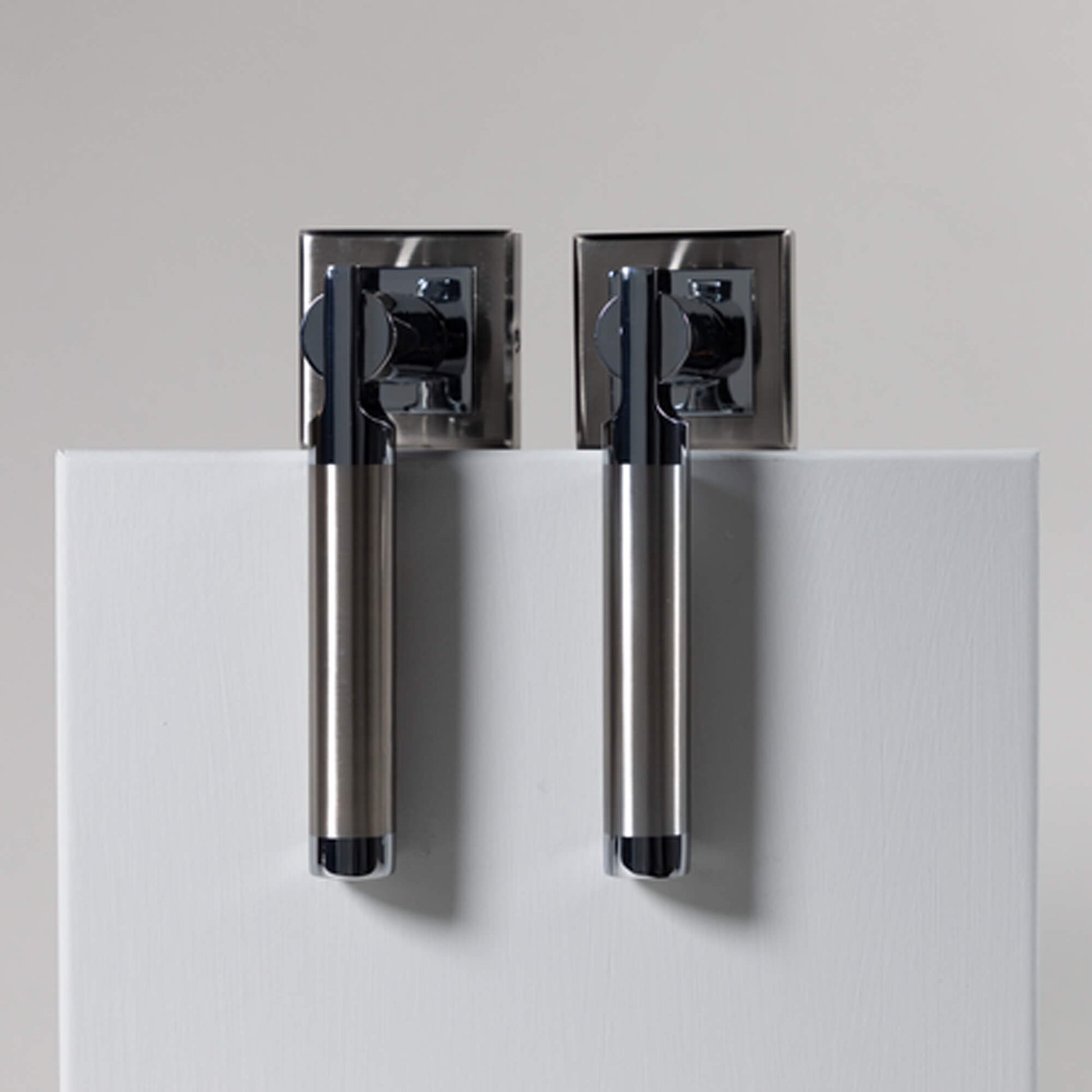 A set of Cumulus Nickel Brushed & Polished Chrome Square Rose Handles on a white background
