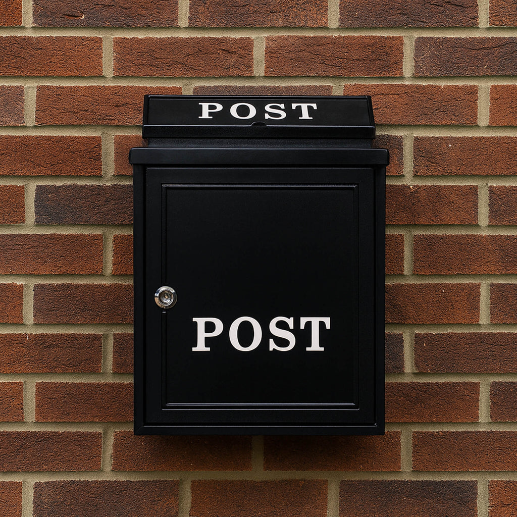 A Devon Black Cast Aluminium Letter Box on a brick wall