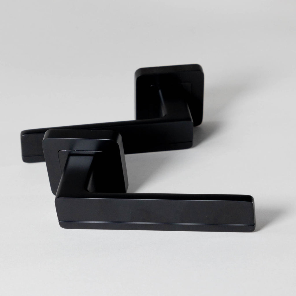 An image of a pair of Hermes Flat Black Square Rose Handles on a light grey background