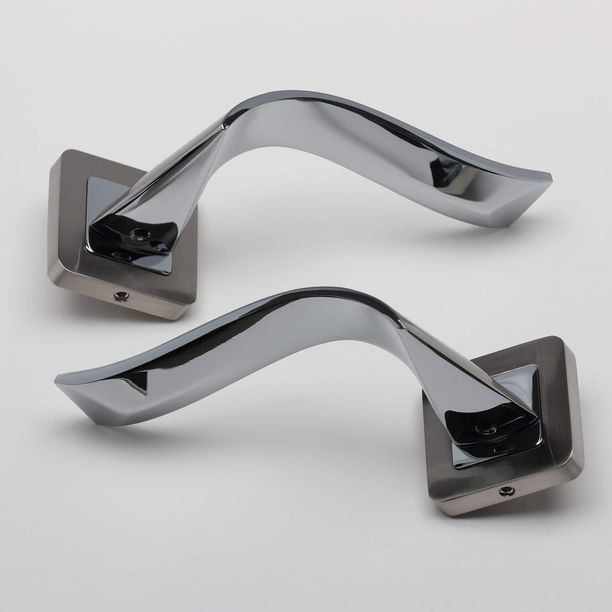 A pair of Incus Nickel Brushed & Polished Chrome Square Rose door handles on a light grey background.
