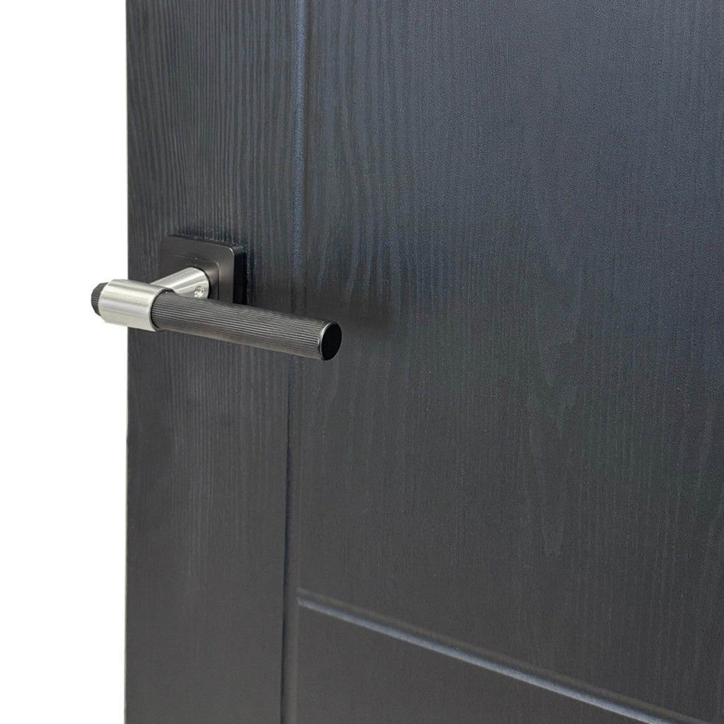 Close-up of an Iseo Black Ash Laminate 35mm Internal Door with a Stratus Flat Black and Nickel Brassed Handle, showing the grooves and woodgrain.