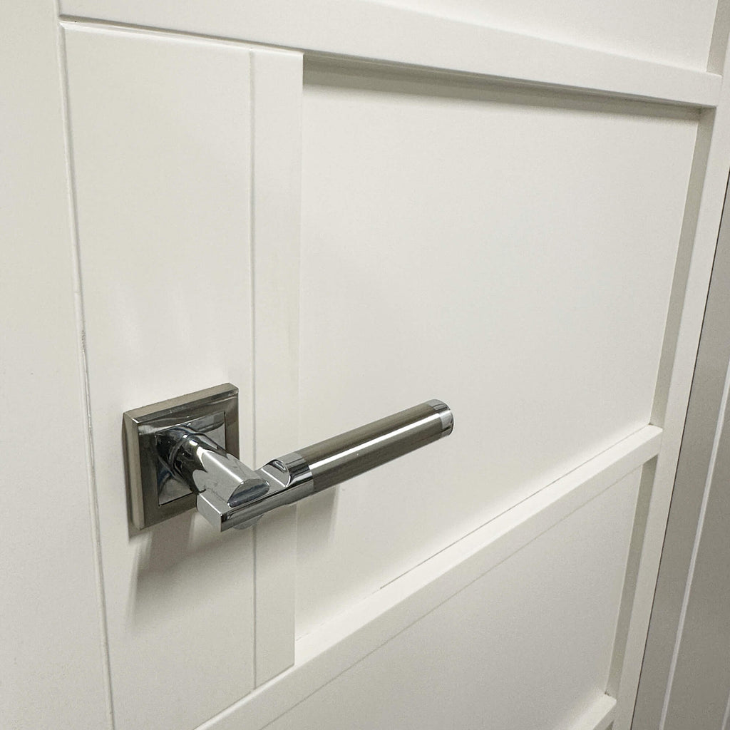 Close-up of a Cumulus nickel brass and polished chrome door handle on a Kew White Primer Plus 5 Panel Door.