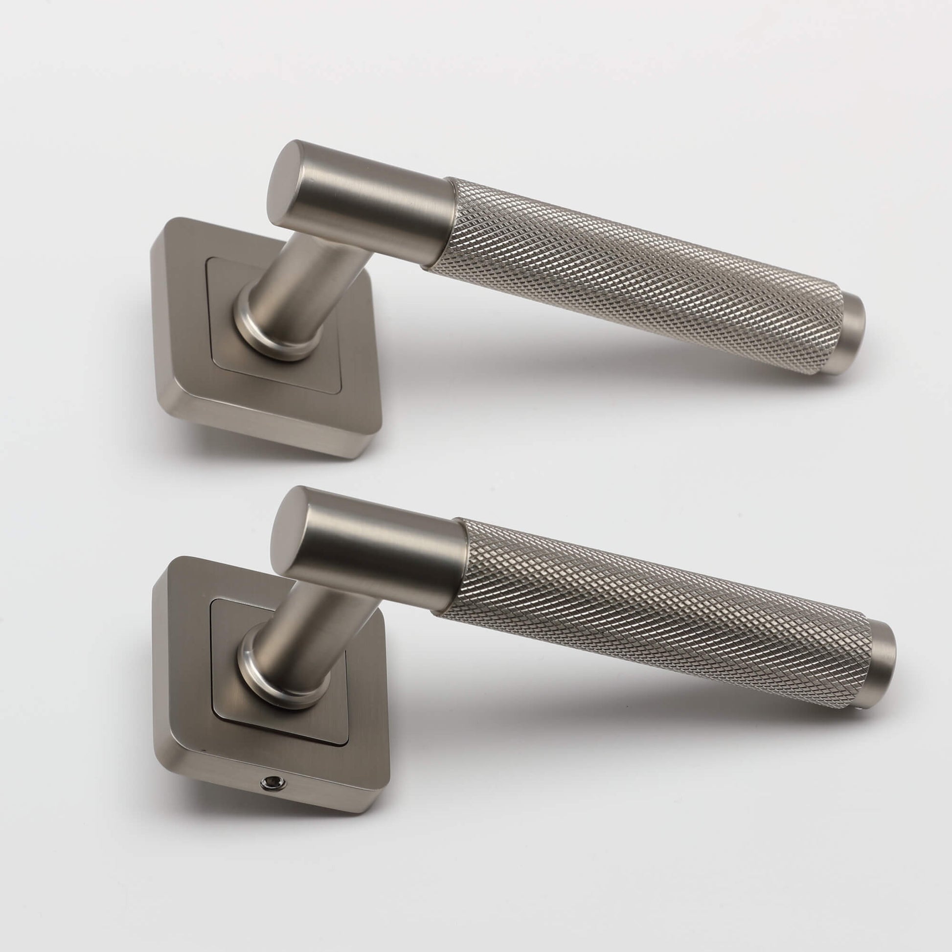 A side view of a pair of Knurled Matt Satin Nickel Square Rose Handles on a light grey background.