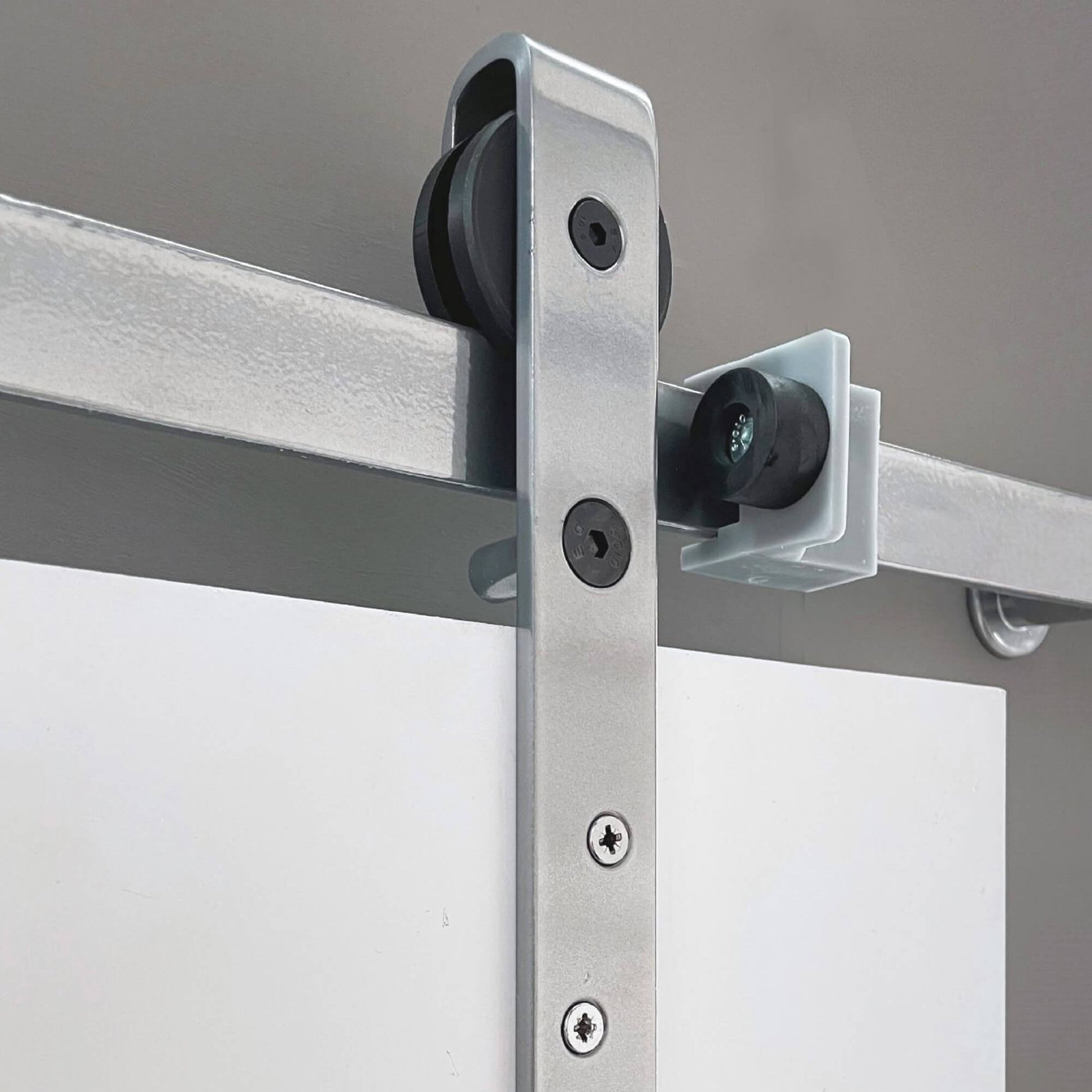 Close up of the steel sliding door mechanism on an Easton and Manhattan White Primed Barn Door Set.