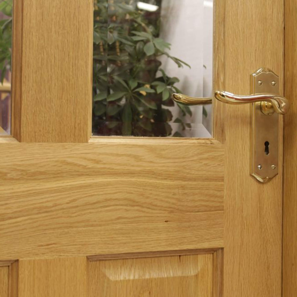 A close-up of an Oxford White Oak Pre-Glazed 40mm Internal Door with a Monet brass handle.