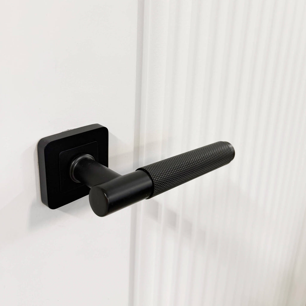 Close-up of Knurled Flat Black Square Rose Handle on a Reeded White Primed 35mm Internal Door.