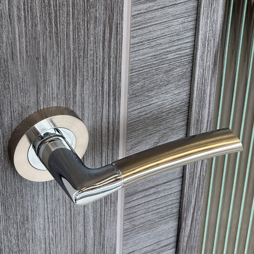 Close-up of a Storm Nickel Brushed & Polished Chrome Handle on a wooden door