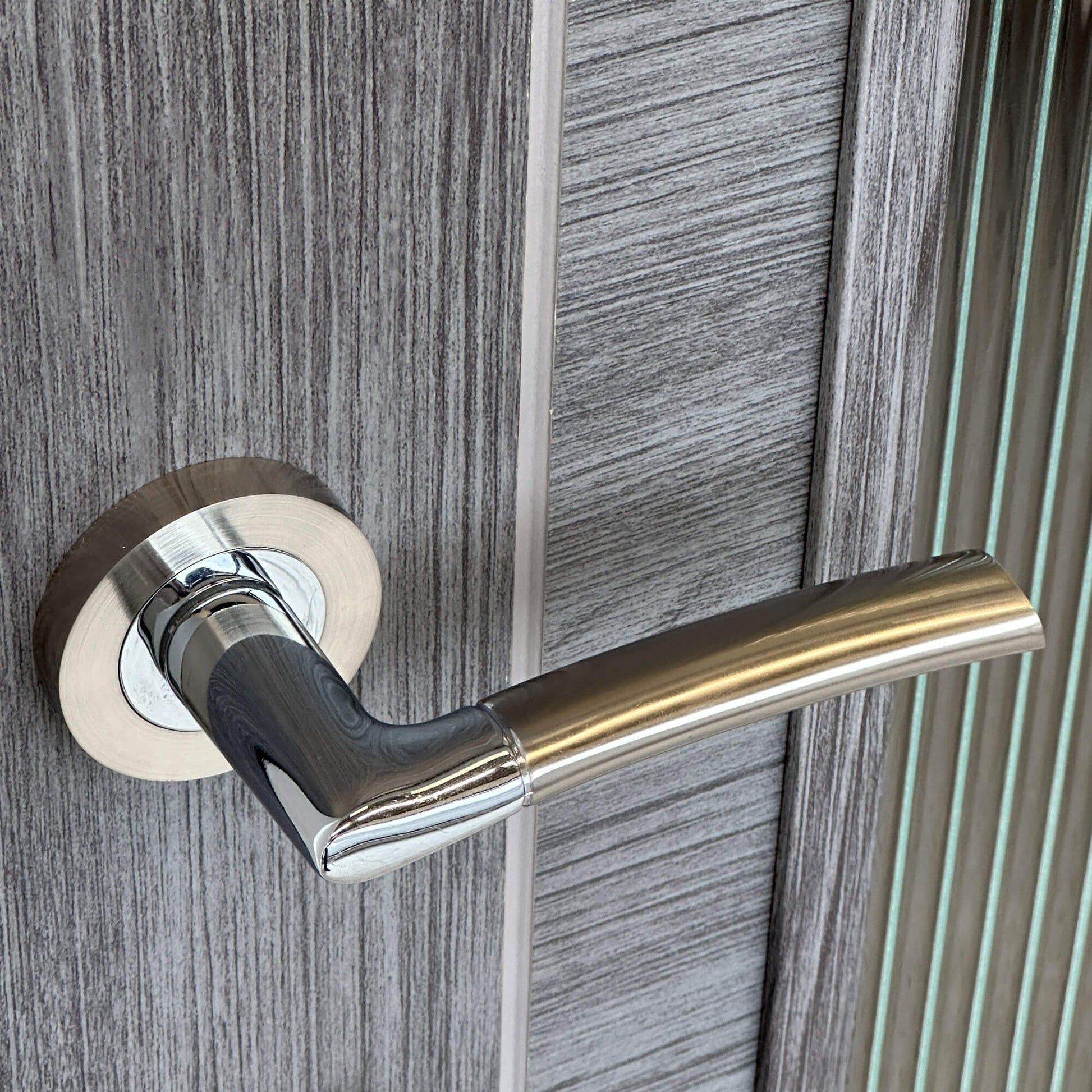 Close-up of a Storm Nickel Brushed & Polished Chrome Handle on a wooden door
