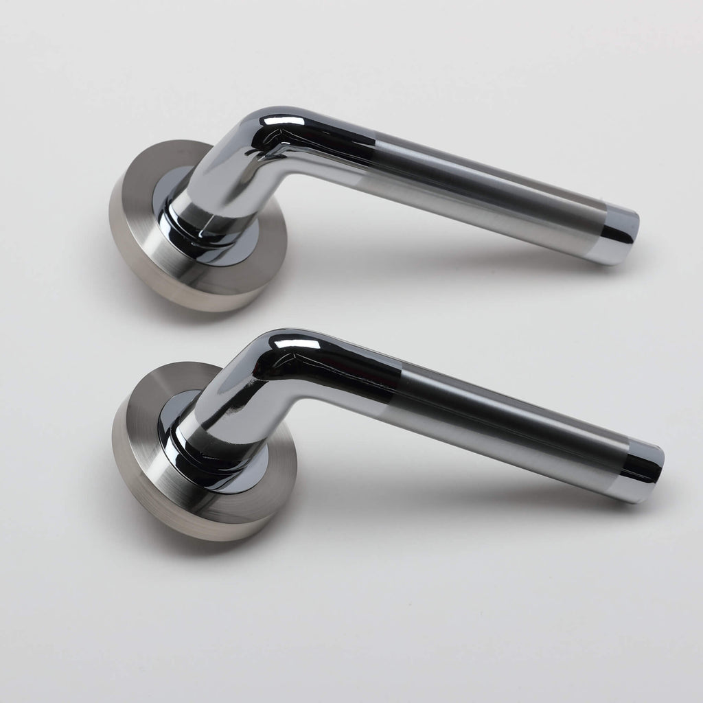 A side view of a pair of Tempest Nickel Brushed & Polished Chrome door handles on a grey background.