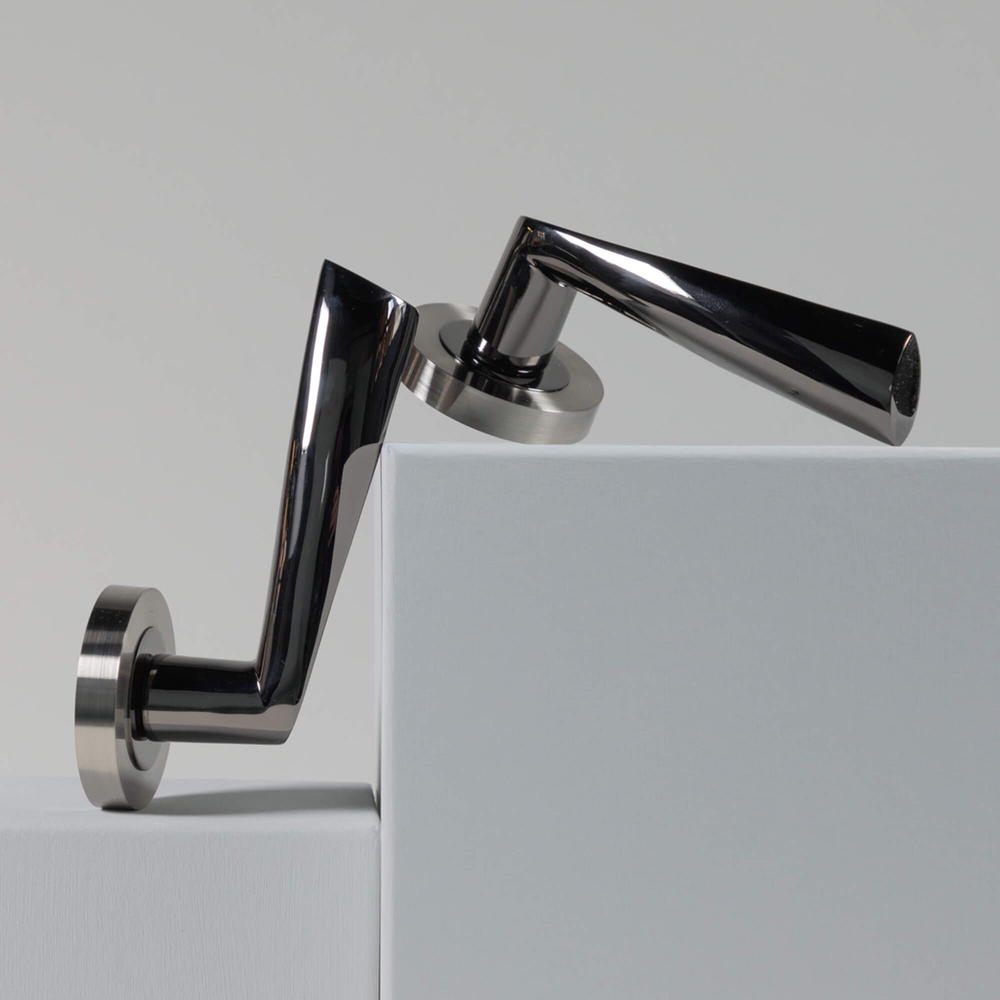 A set of Trade Range Black Nickel & Nickel Brushed door handles on a white door with a grey background.