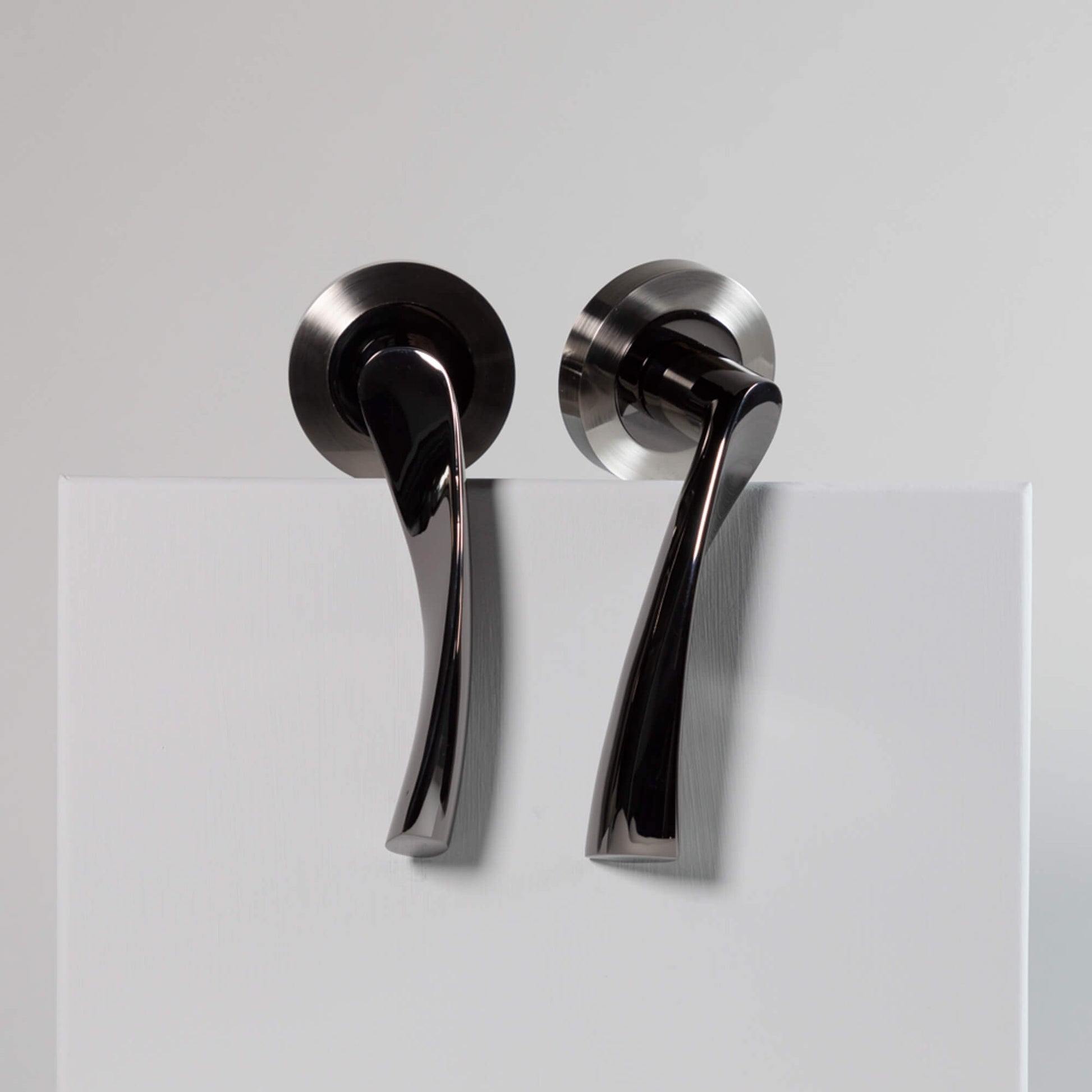 A pair of Trade Range Black Nickel & Nickel Brushed Handles on a grey background
