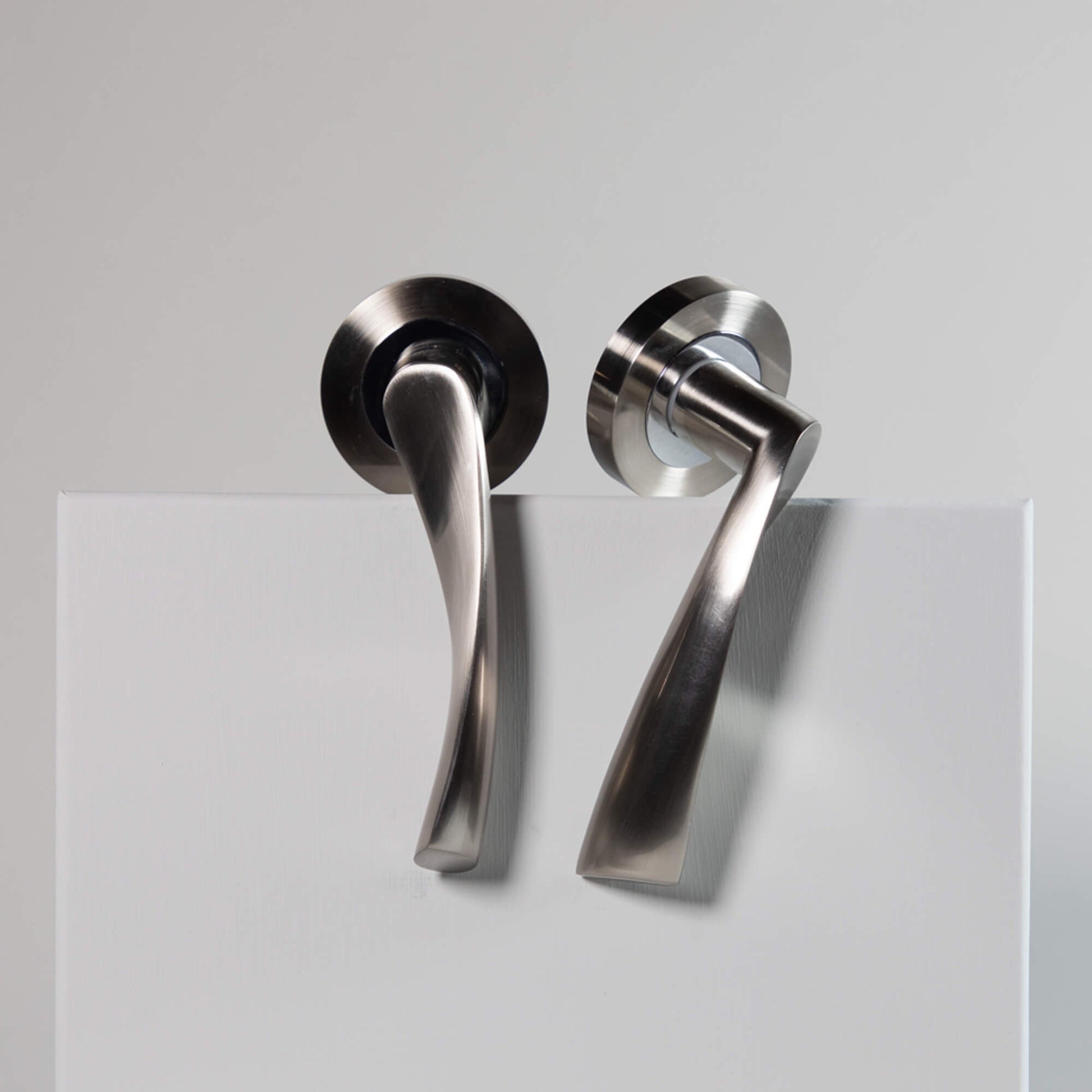 Pair of Trade Range Nickel Brushed & Polished Chrome door handles on a grey background