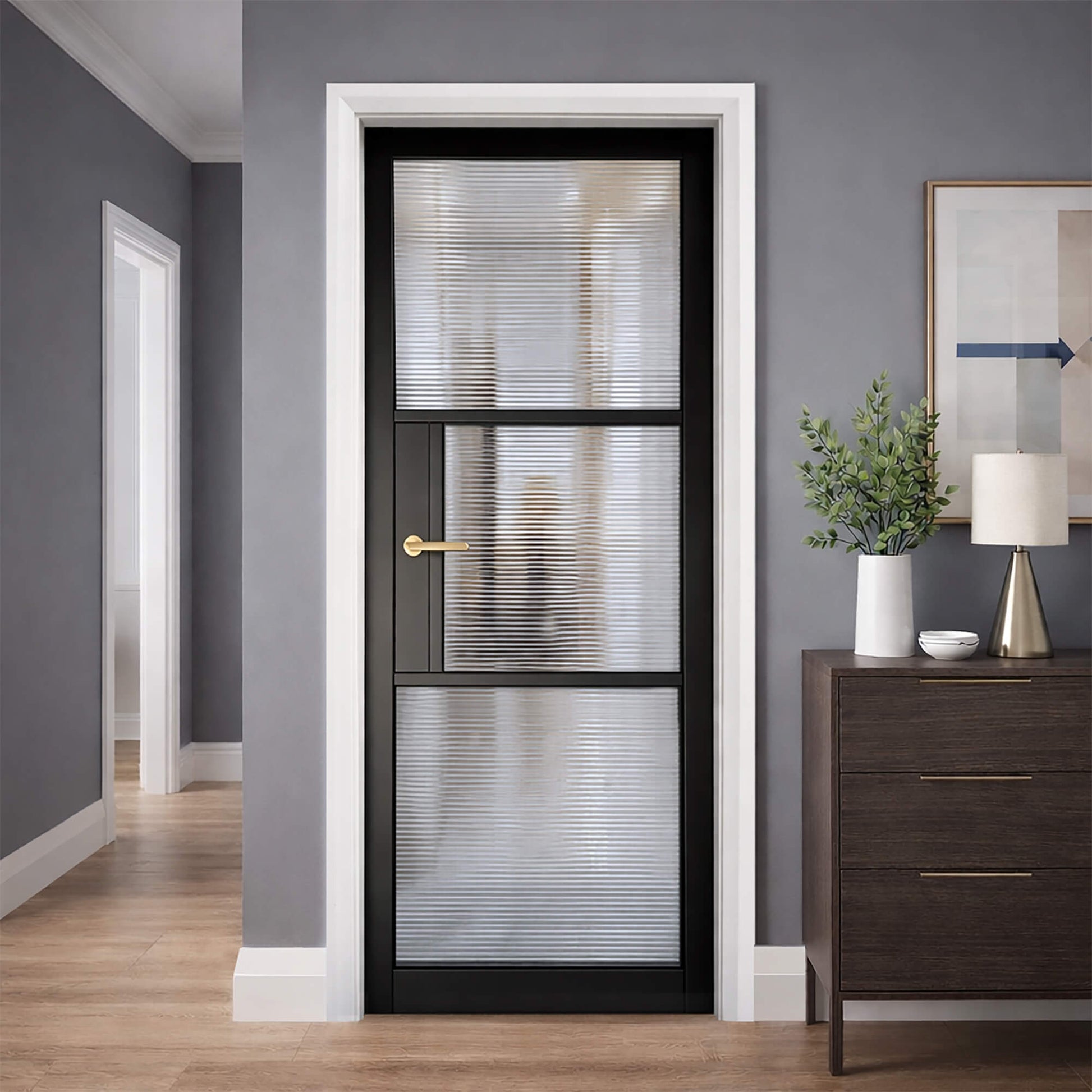A Tribeca Black Primer Plus 3 Lite Reeded 40mm Internal Glass Door in an interior setting with grey walls and wooden flooring.