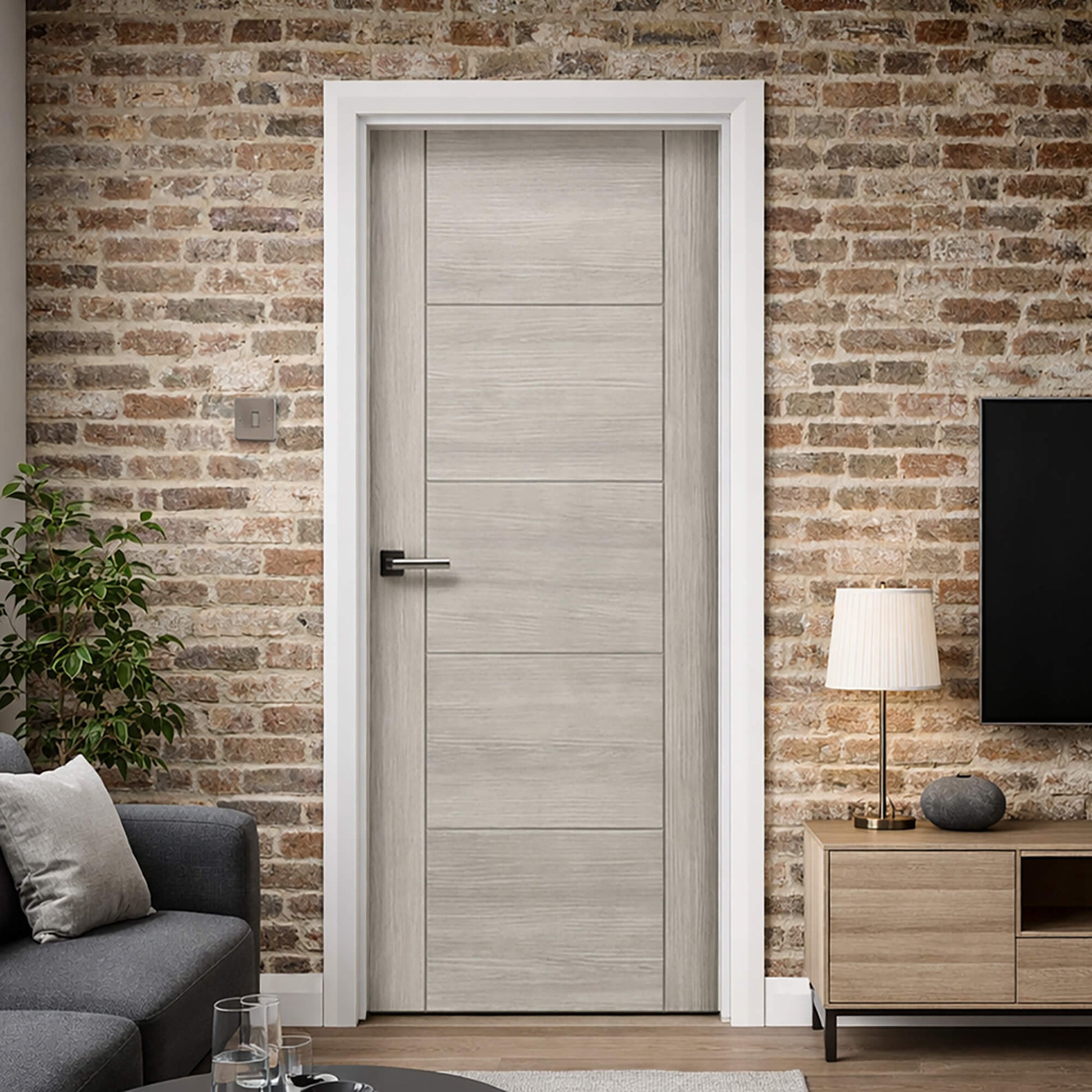 A Vancouver Stone Grey 40mm Internal Laminate Door in a modern home interior setting with a brick wall.