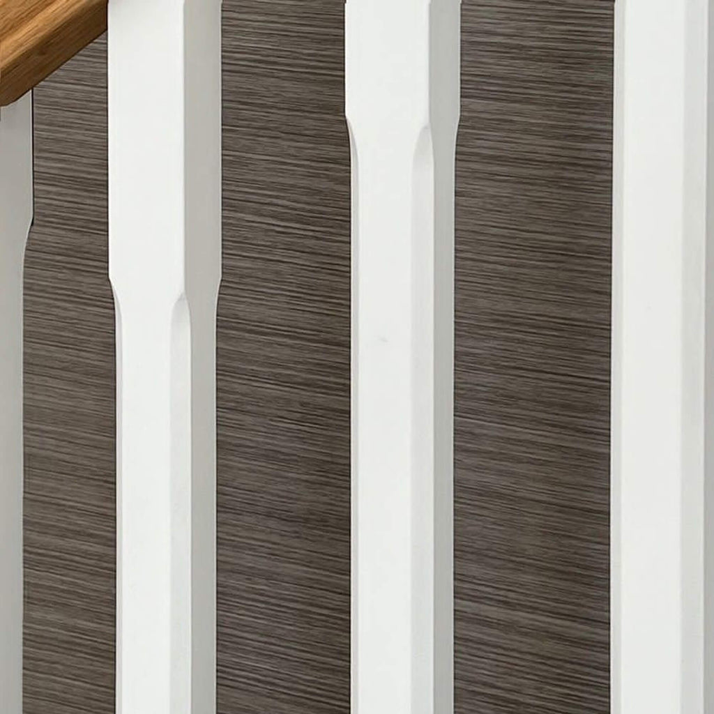 Close-up of White Primed Chamfered Spindles with a wallpapered background
