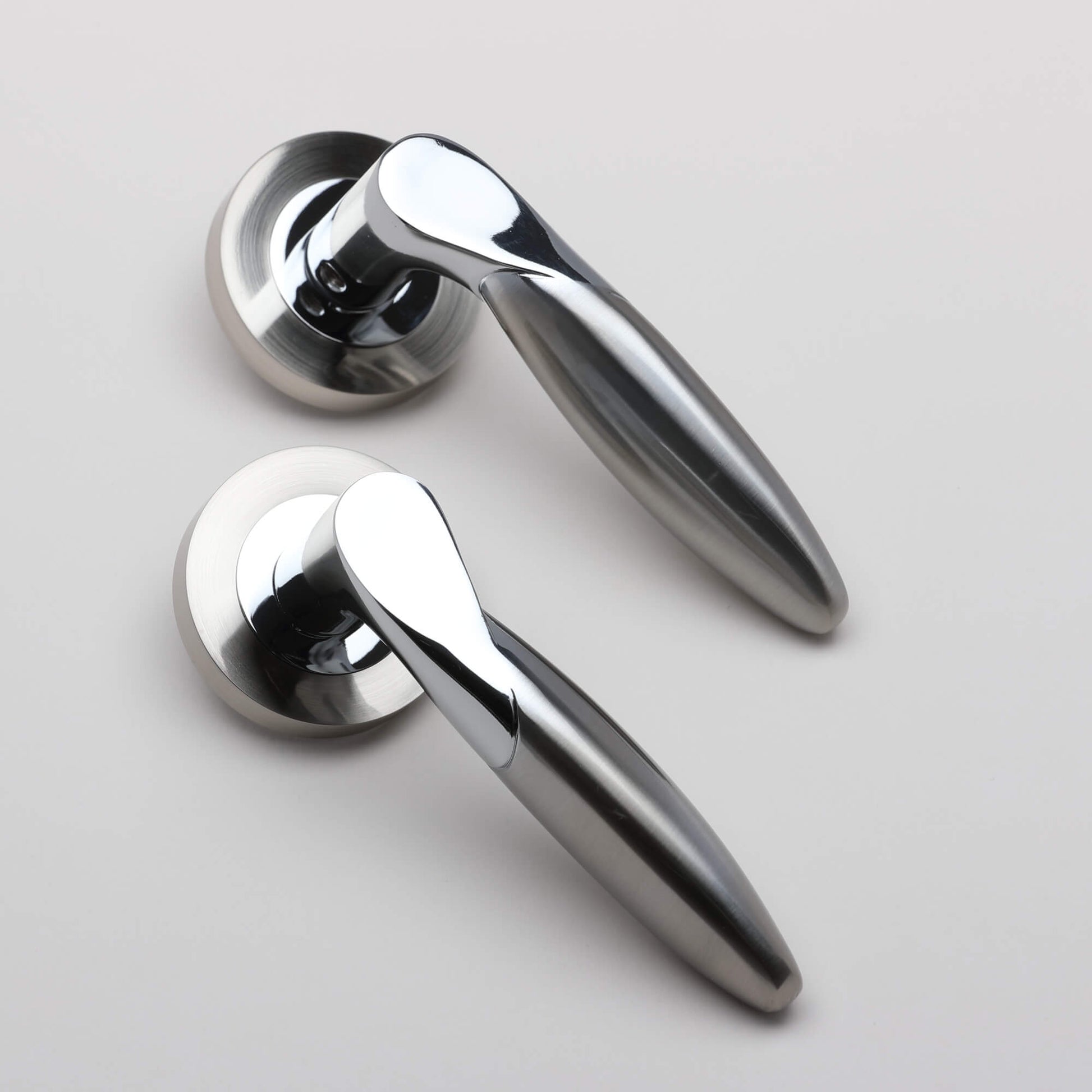 A pair of Zeus Nickel Brushed & Polished Chrome Handles on a grey background